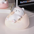 Close-up of white cat night light on pink base, cat face with sleepy expression
