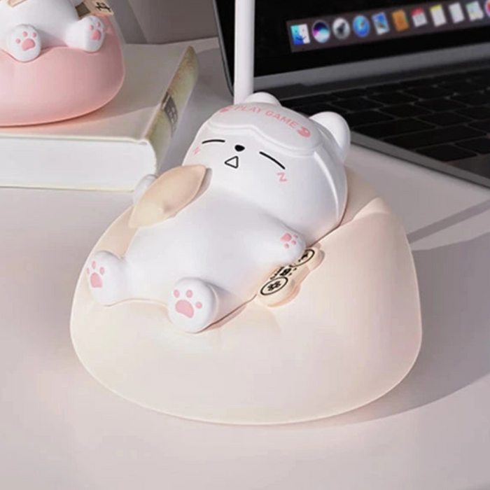 Close-up of white cat night light on pink base, cat face with sleepy expression