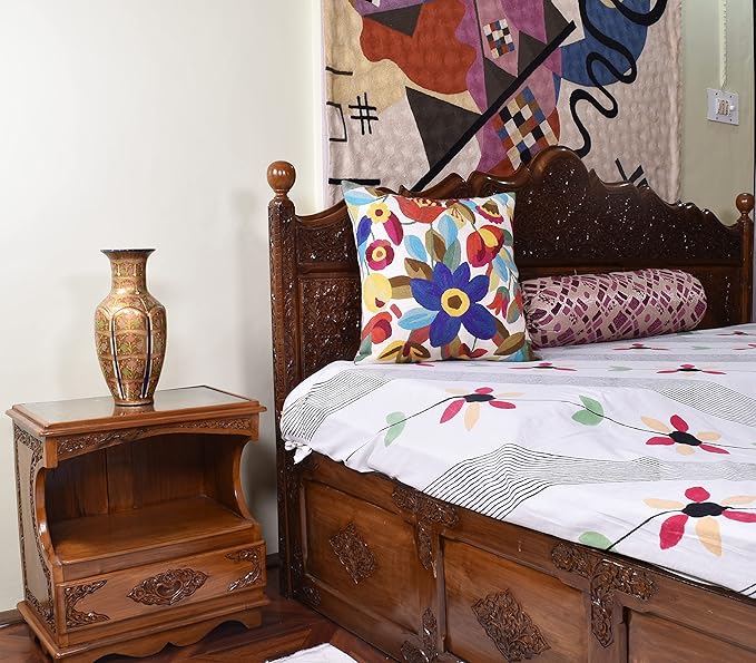 Floral throw pillow on bed, multicolor flower embroidery on white fabric