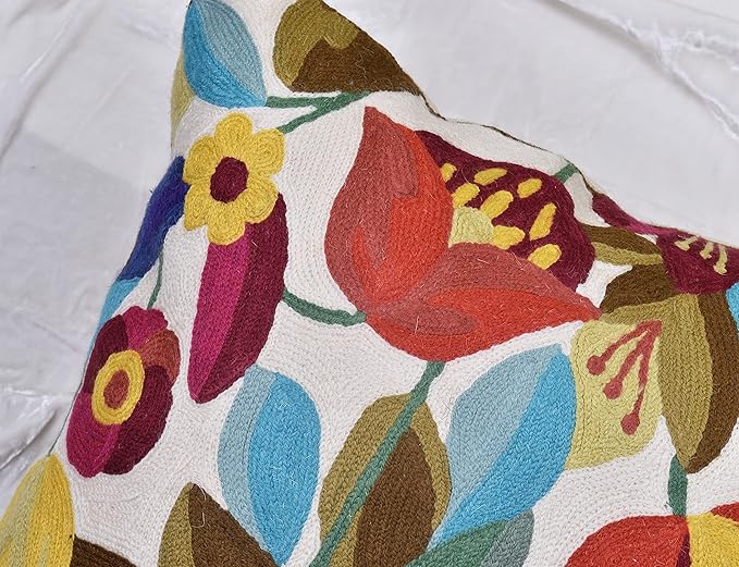 Close-up of red, blue, and yellow flowers on white embroidered pillow cover