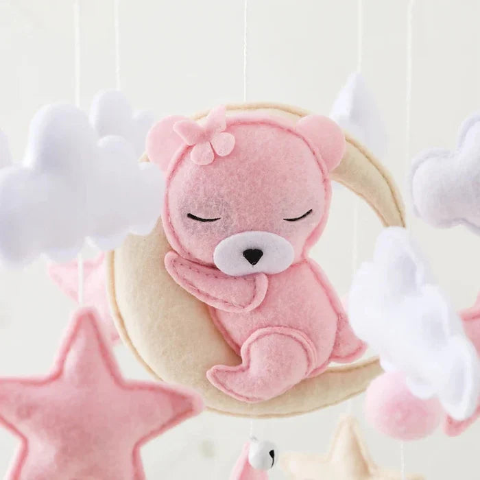 Felt bear plush on a moon cushion with white cloud accents and hanging charm below