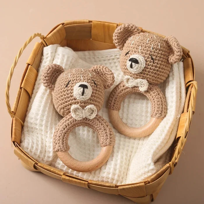 Set of two crochet teddy bear teethers with wooden rings in a woven basket
