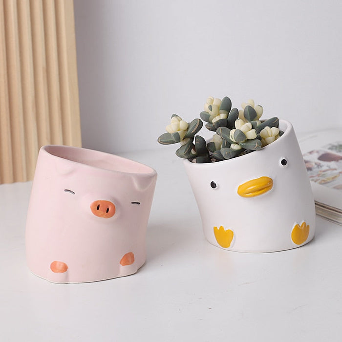 Duck-shaped ceramic planter, white with yellow beak and orange feet details.