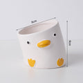 White duck ceramic planter with yellow beak and orange feet; 9cm wide, 6cm high.