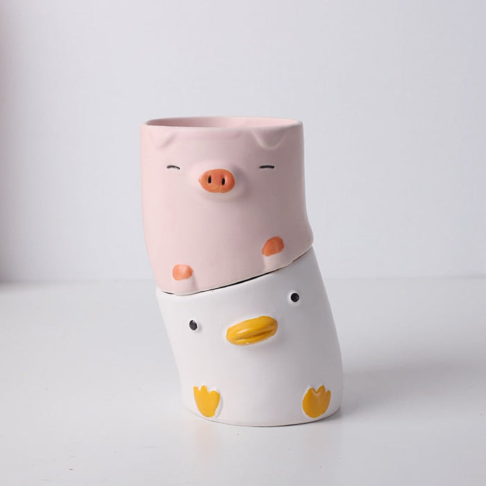 Stacked pig and duck ceramic planters, pink pig on top of white duck.