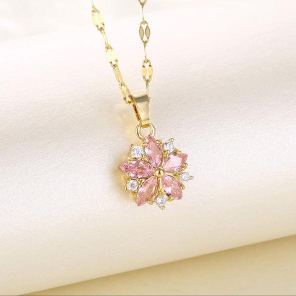 Gold-tone pendant necklace with pink cherry blossom flower and clear crystal accents