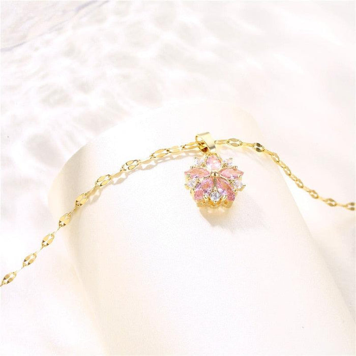 Gold-tone chain necklace with pink cherry blossom pendant on short necklace loop
