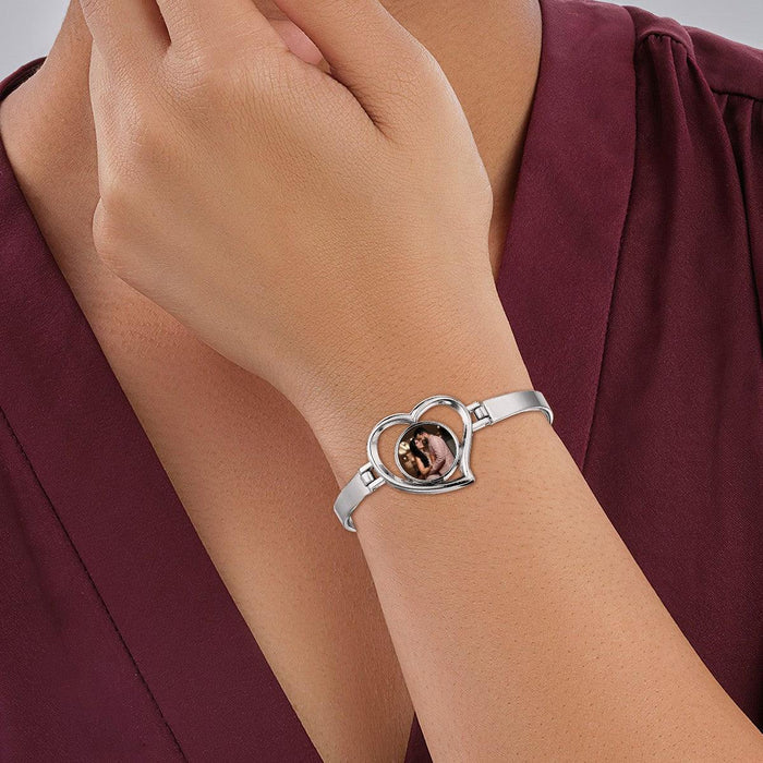 Silver-tone heart photo bracelet on wrist with inset heart portrait