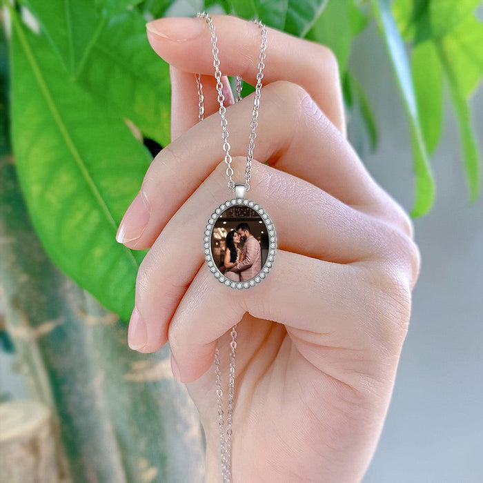 Silver chain photo pendant with oval frame and rhinestone border