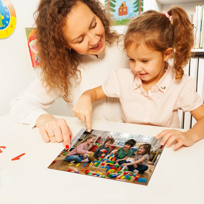 Wooden photo puzzle being assembled by two children at a table, pieces scattered