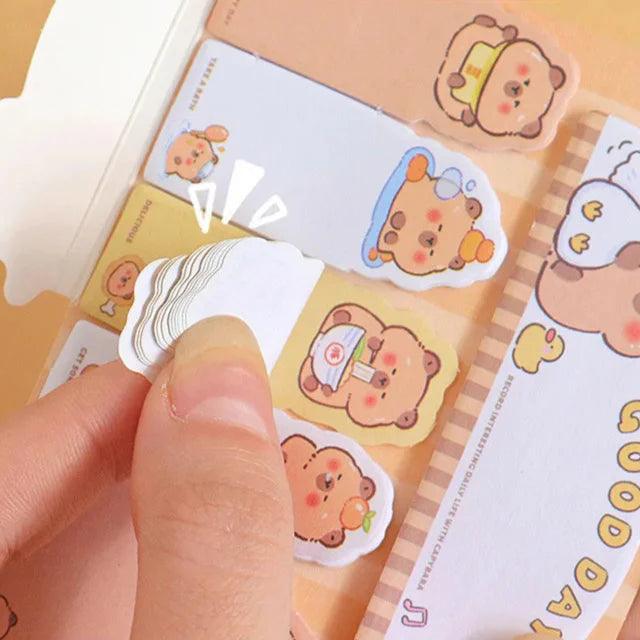 Capybara bookmark sticky note pressed onto a card, showing small cartoon character art