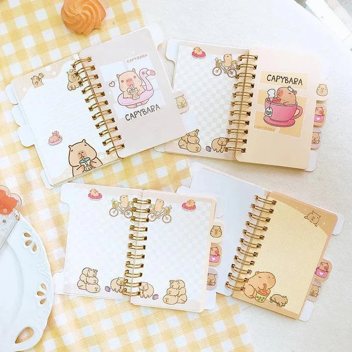 Mini notebook set on plaid fabric, capybara graphic covers with gold spiral binding