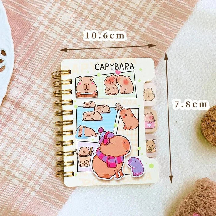 Capybara mini notebook with pastel cover art, gold spiral rings, size labels shown