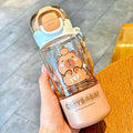 Clear capybara water bottle with peach base and flip lid, held by a hand
