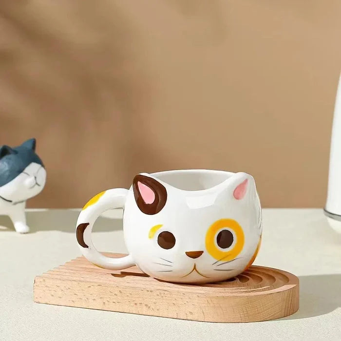 Cat ceramic mug with white body and yellow eye patches, brown nose and whiskers