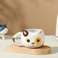 Cat ceramic mug with white body and yellow eye patches, brown nose and whiskers