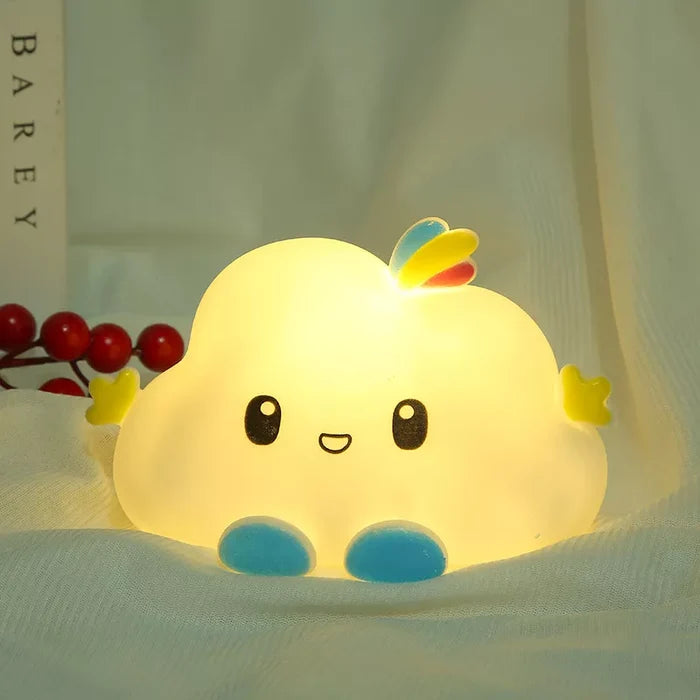 Cloud LED night light tucked under bedding, showing a cute face and blue feet.