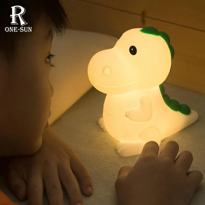 Dinosaur night light glowing warm yellow with green tail and body details