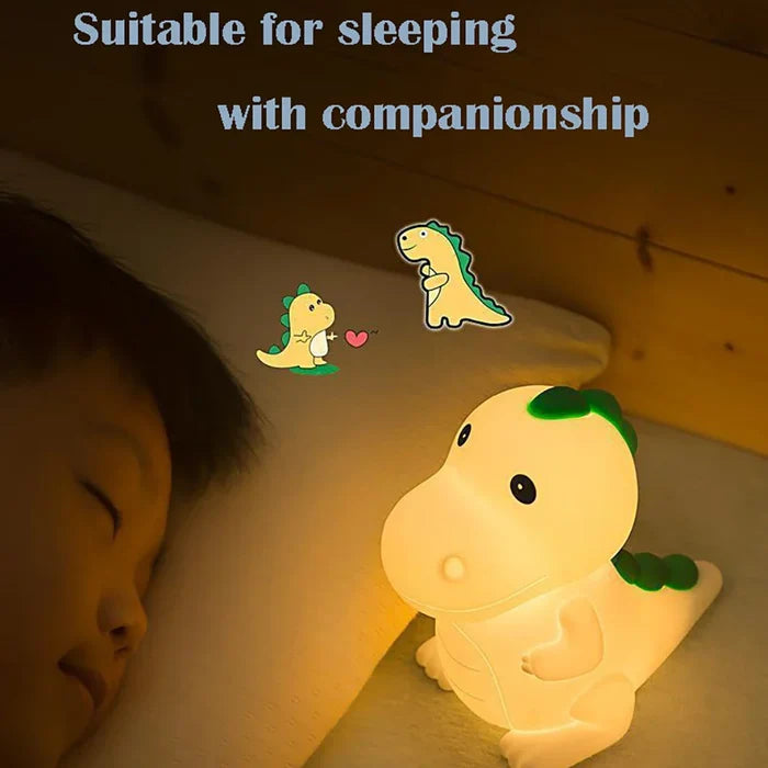 Glowing dinosaur night light with green tail, resting on a bed