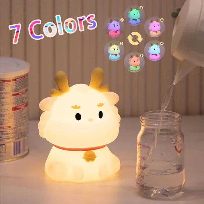 Cute dragon night light with rounded face, small hands, and warm LED glow