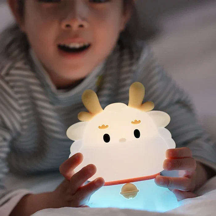 Cute dragon night light held in hands, soft blue glow and rounded face