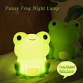 Silicone frog night light, glowing yellow frog figurine on bedding
