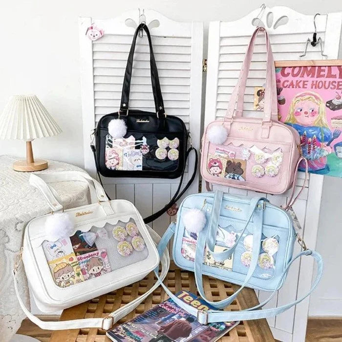 Assorted Ita messenger bags in black, pink, and light blue, each with character patchwork