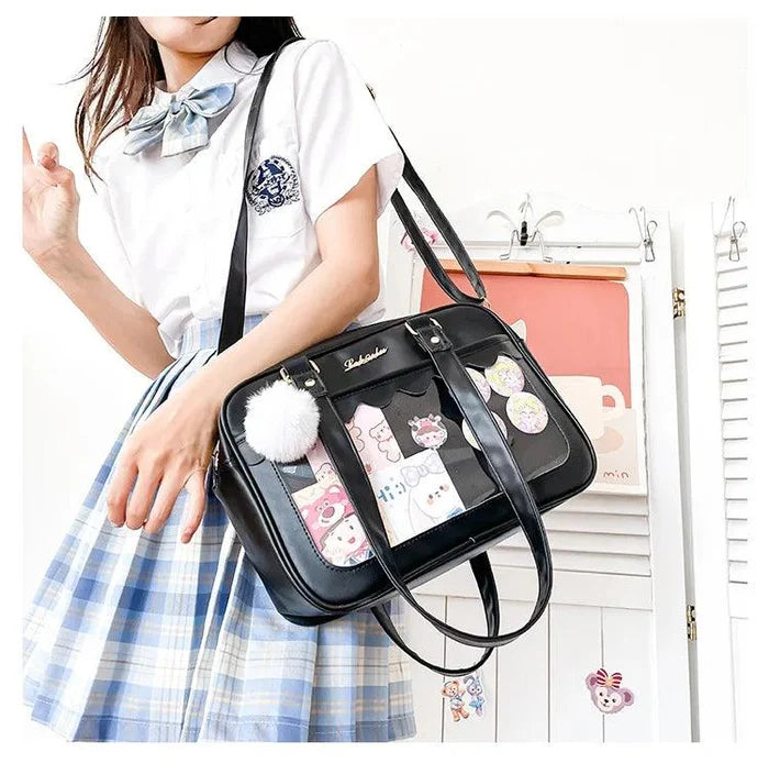 Black Ita messenger bag with character patchwork window, pom-pom charm, shoulder straps