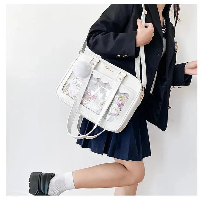 White Ita messenger bag with scalloped flap and character collage window, crossbody strap