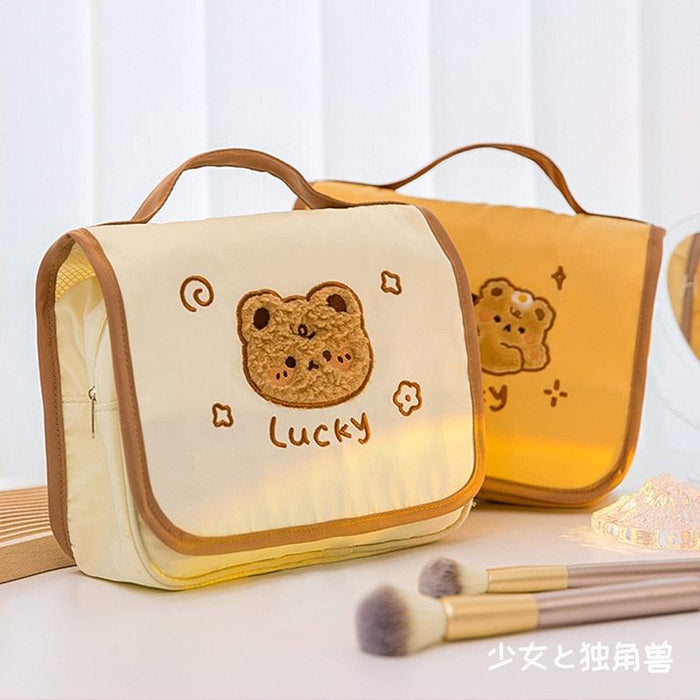 Cute makeup bag with tan-collared top handle and bear applique, cream front panel