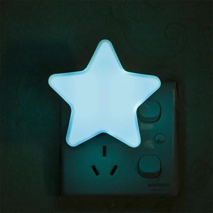 Star plug-in night light with cool white glowing star on a wall outlet