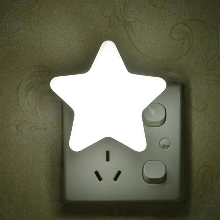 Star plug-in night light with bright white glowing star on wall outlet