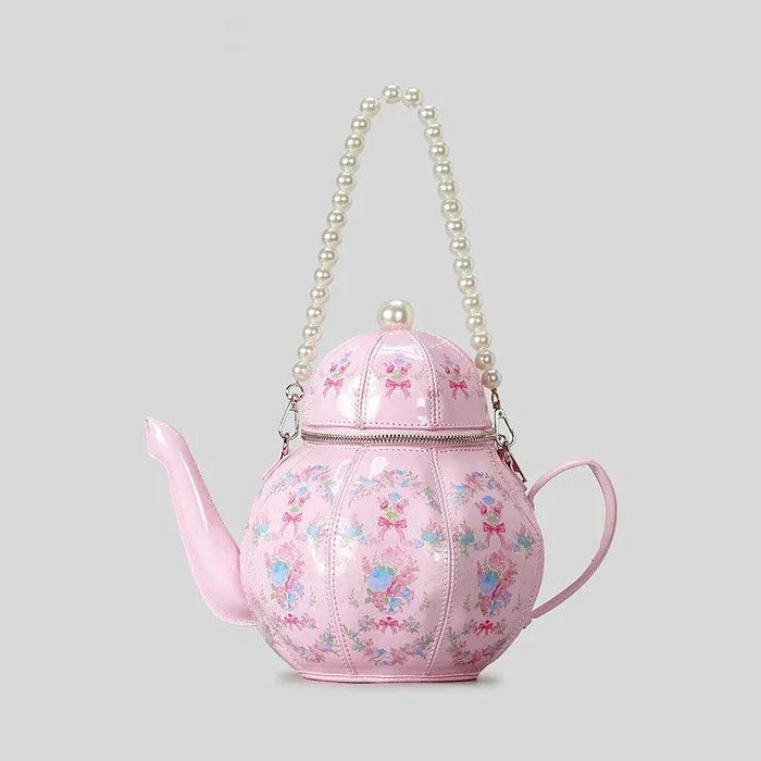 Pink teapot-shaped tea party bag with pearl-look chain and floral bow accent