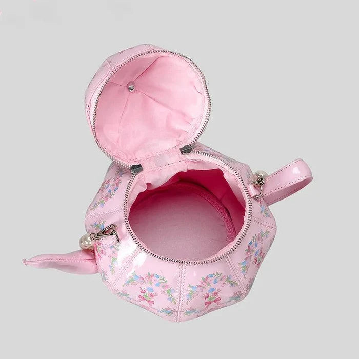 Pink teapot-shaped tea party bag with floral pattern and open top