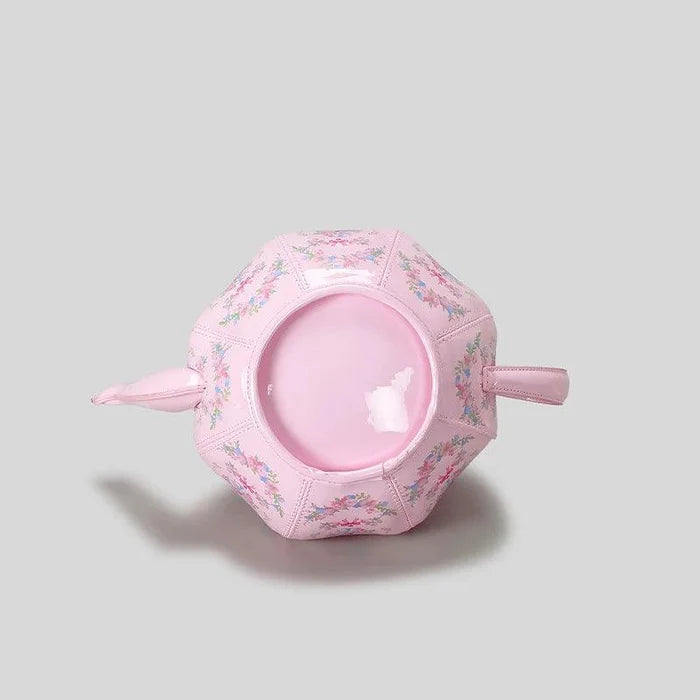 Pink teapot-shaped mini bag with floral print and round front opening
