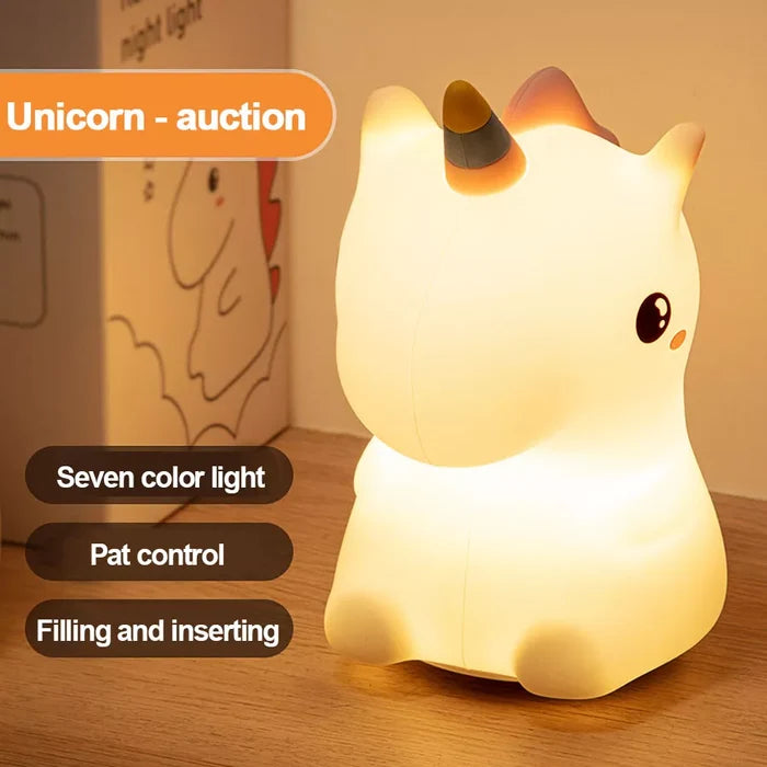 Unicorn LED night light standing on a wood surface, warm white glow