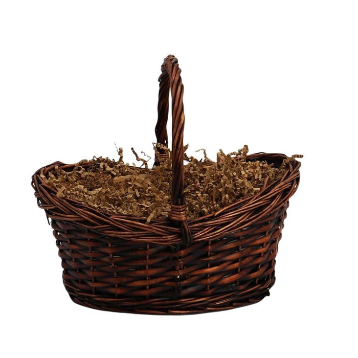 Wicker gift basket with shredded filler and raised handle, ready for filling