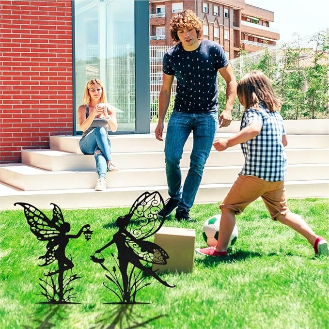 Black metal fairy garden stakes on lawn, featuring three different fairy silhouettes