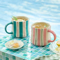 Ceramic coffee mug set, 2-pack, striped pink-and-green with rounded handles