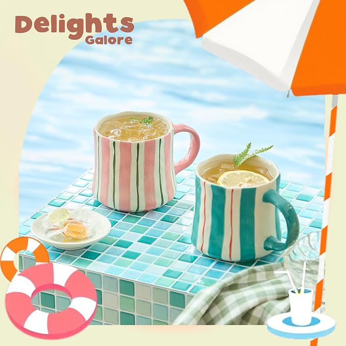 Two striped ceramic mugs, one with pink handle and one with green handle