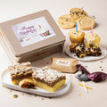 Deluxe birthday gift tin with assorted cookies and cake on plates