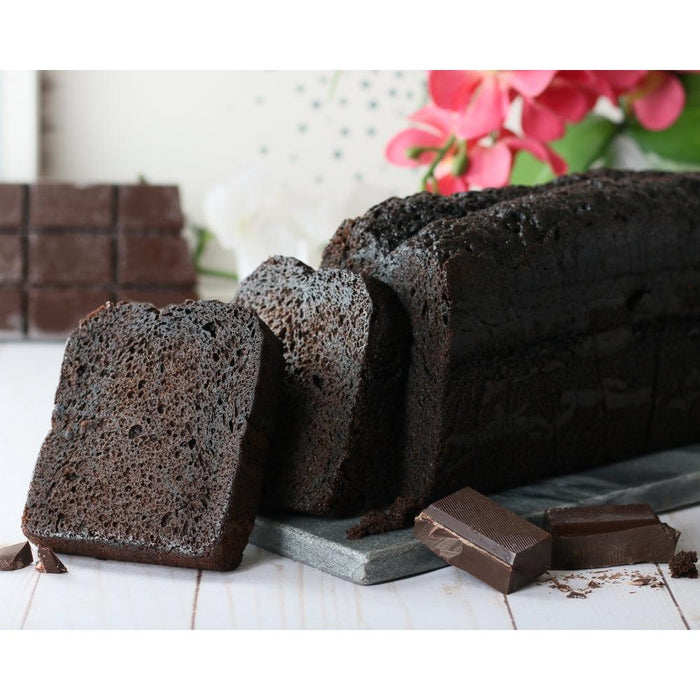 Chocolate loaf cake slices on a tray with assorted chocolate pieces