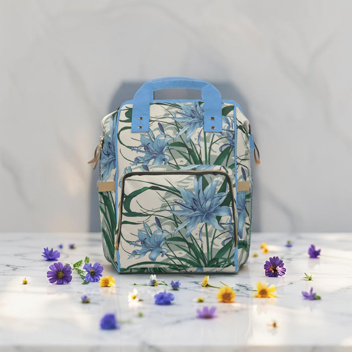 Diaper backpack in blue floral print, front view with double zip pockets