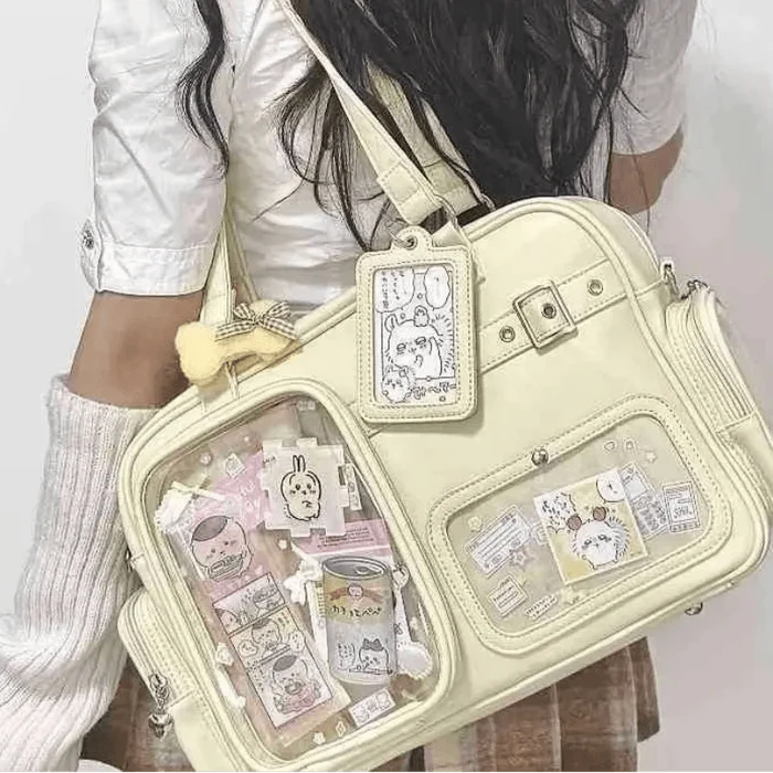 Pastel crossbody bag in light cream with zip pockets and a front charm card holder