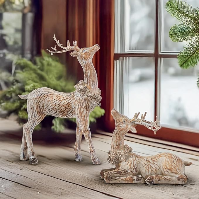 Two brown resin reindeer figurines standing and lying near a window ledge