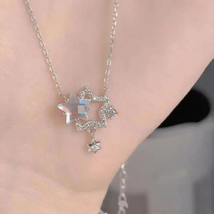 Star-shaped rhinestone pendant necklace on silver chain with blue center gem