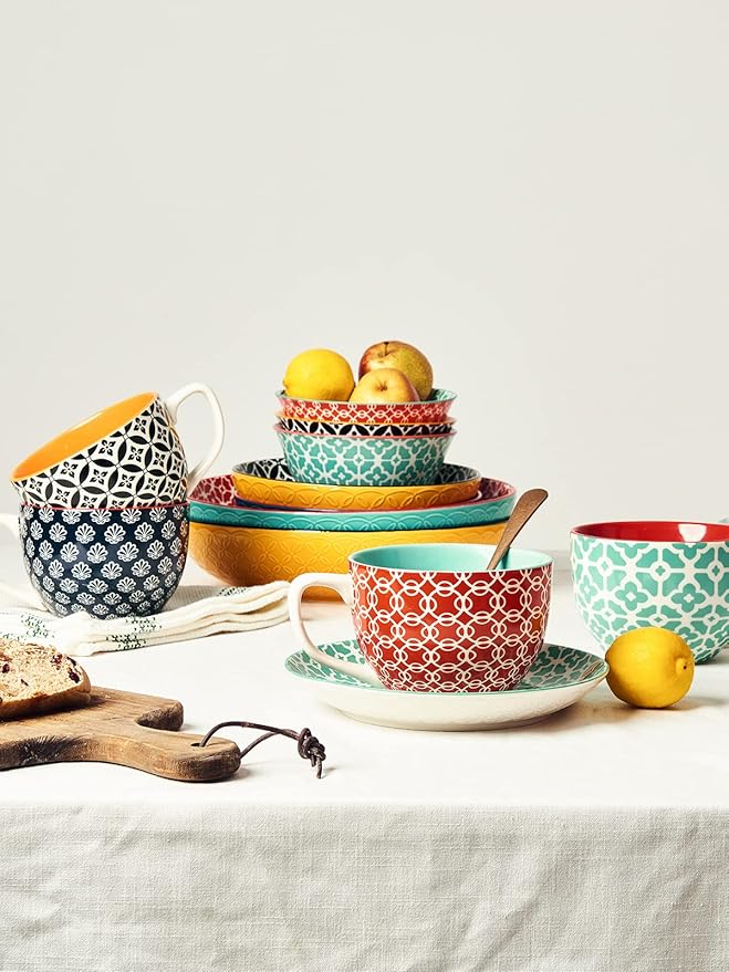 Assorted ceramic coffee mugs with handles, teal lattice, red geometric, and black and white pattern