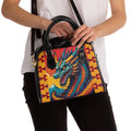 Dragon graphic shoulder handbag with black handles and yellow geometric sides