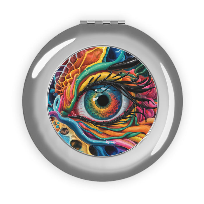 Silver glossy compact mirror with round colorful dragon-eye artwork on the closed lid