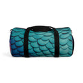 Teal mermaid-scales duffel bag with black strap, shown from the side.